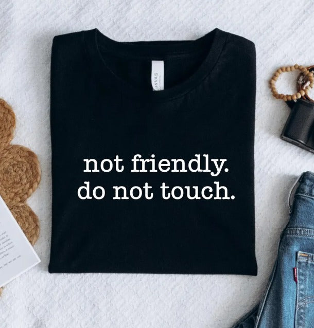 Black graphic tee by Anchored Grace Boutique with "Not Friendly Do Not Touch" design, casual fit, and bold statement print.