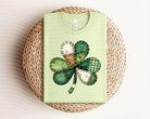 Patchwork clover graphic tee from Anchored Grace Boutique, featuring colorful patchwork design and a playful clover graphic.