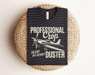 Black graphic tee featuring a crop duster airplane design from Anchored Grace Boutique, casual and stylish for everyday wear.