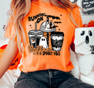 Graphic tee featuring "Running on Coffee and Spooky Vibes" design, black short-sleeve shirt from Anchored Grace Boutique.