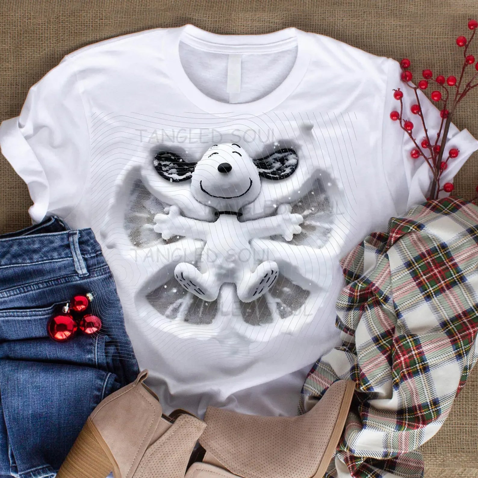Snoopy Snow Angel graphic tee by Anchored Grace Boutique showing a playful Snoopy design on a casual cotton t-shirt.