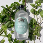 Bottle of Ancient Health & Healings peppermint mouthwash showing the label and clear liquid inside.
