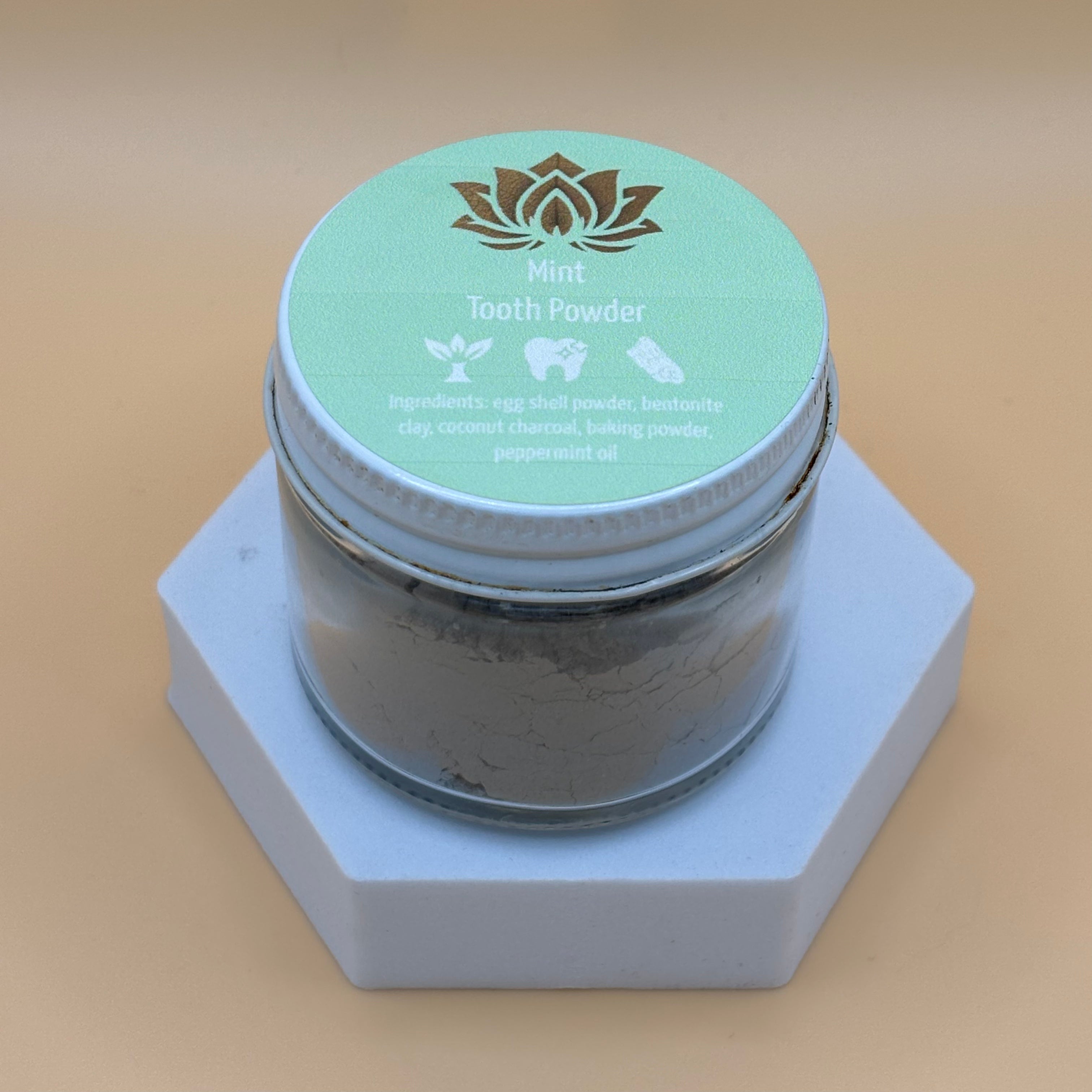 Ancient Health & Healings peppermint remineralizing tooth powder in a jar, showing the natural herbal ingredients and product packaging.