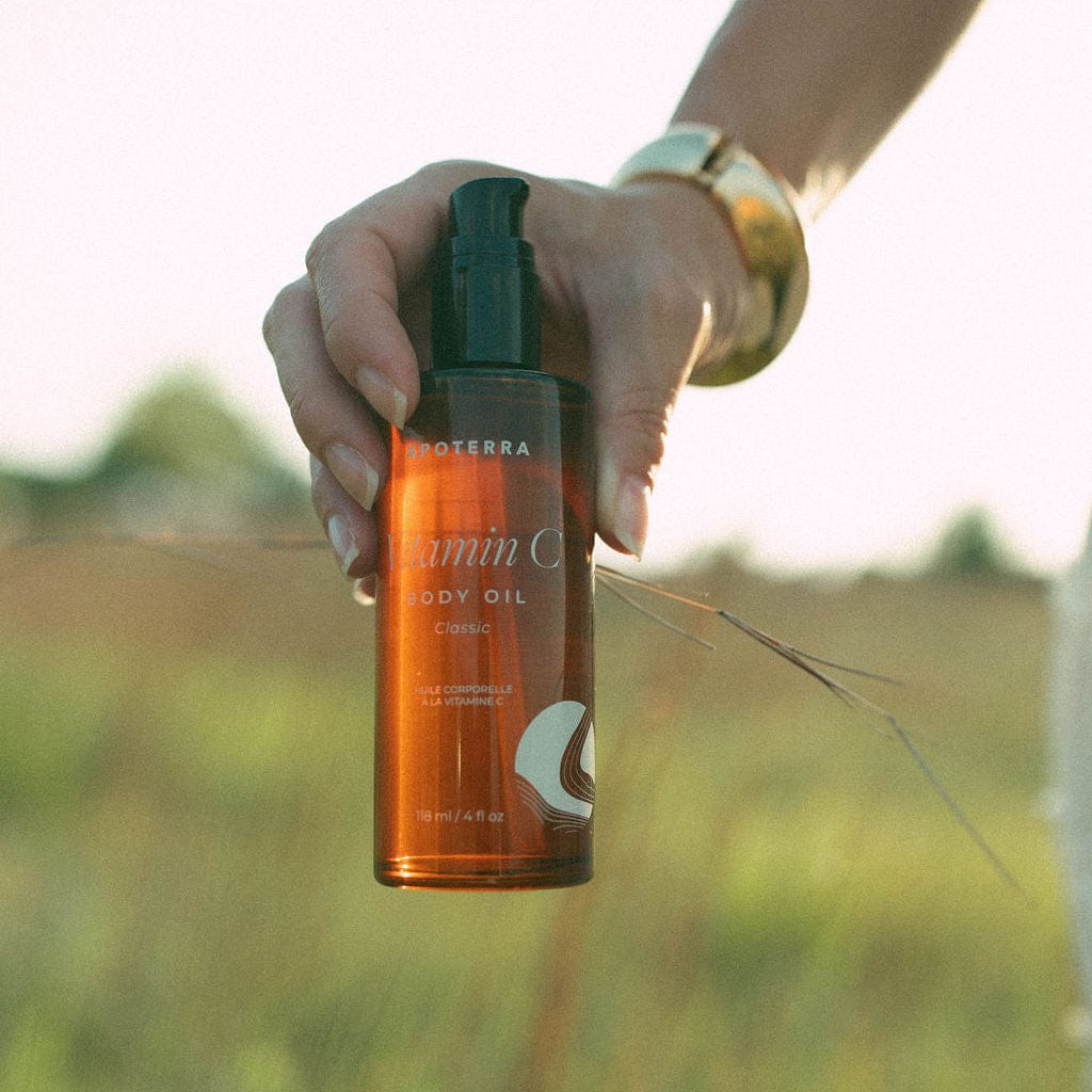 Apoterra Vitamin C Body Oil bottle and skincare setup for bath and body use in a natural lifestyle scene.
