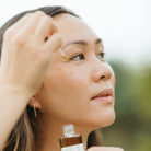 Women applying Apoterra Green Tea Clarifying Facial Oil, natural skincare facial oil for glowing, healthy skin.