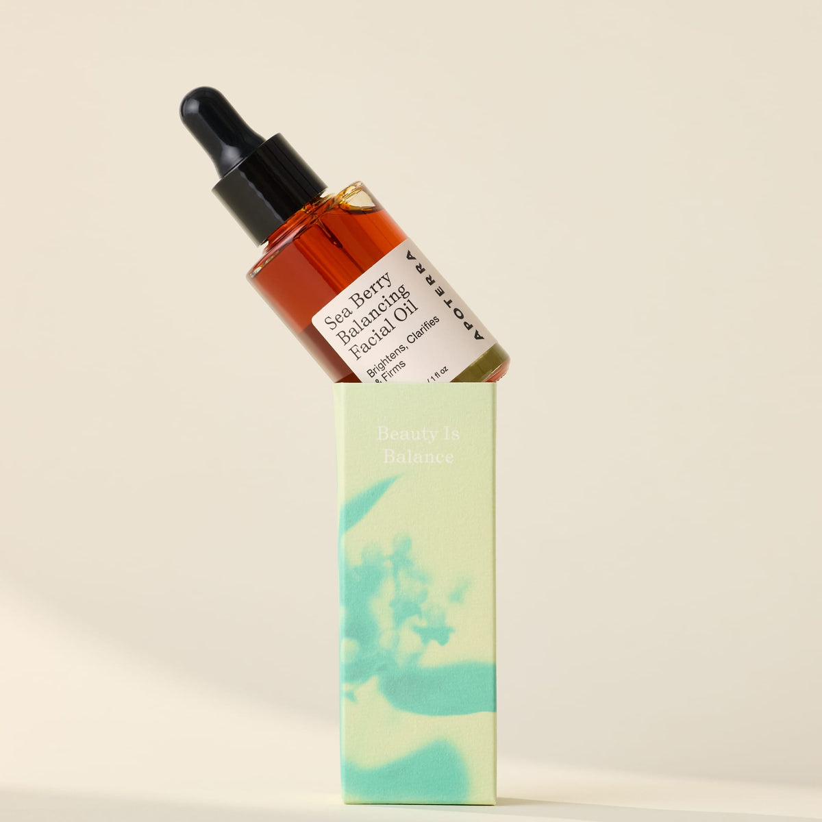 Apoterra Sea Berry Balancing Facial Oil resting on its box, featuring a sleek dropper bottle and natural sea berry ingredients.