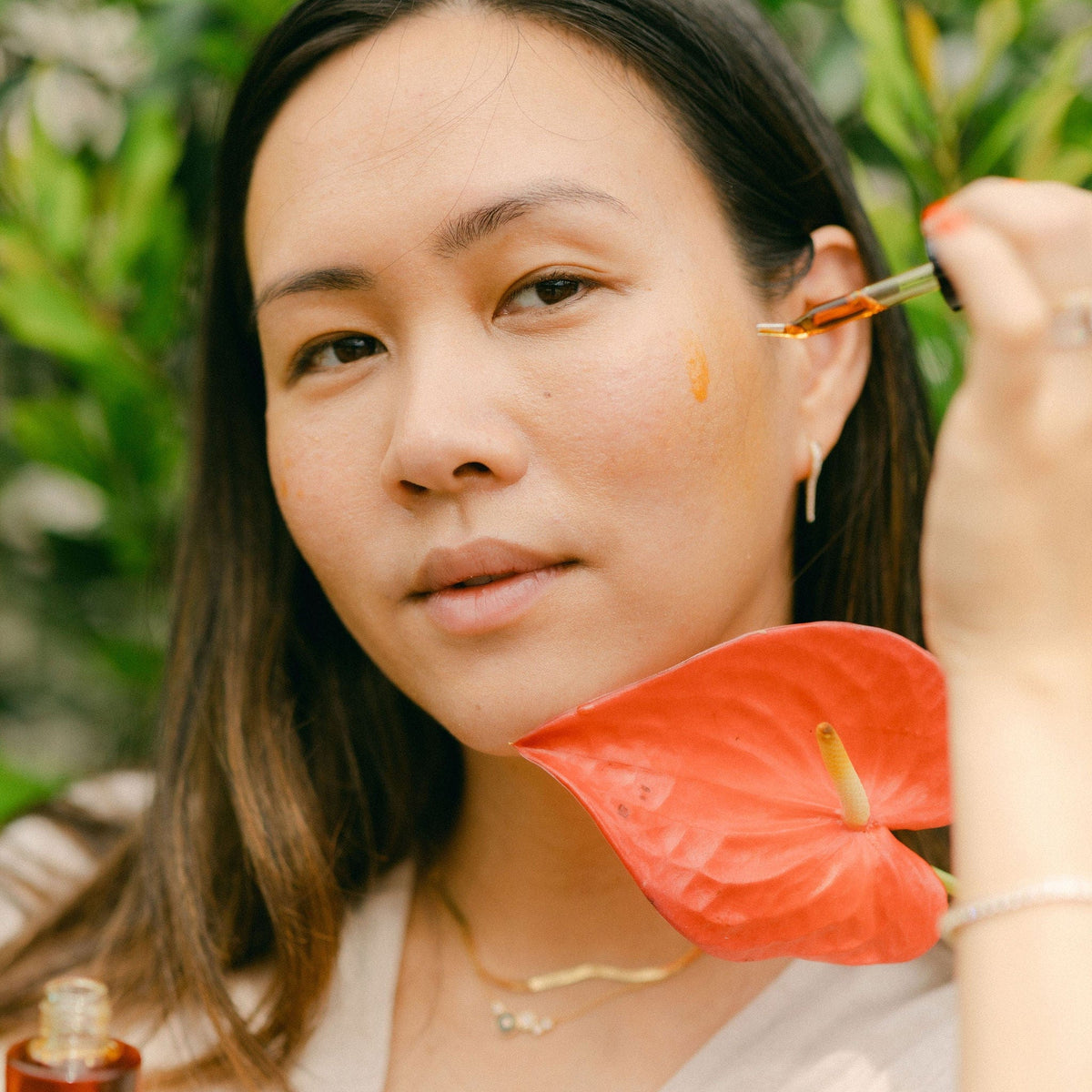 Woman applying Apoterra Sea Berry Balancing Facial Oil, natural skincare product for balanced, healthy skin.