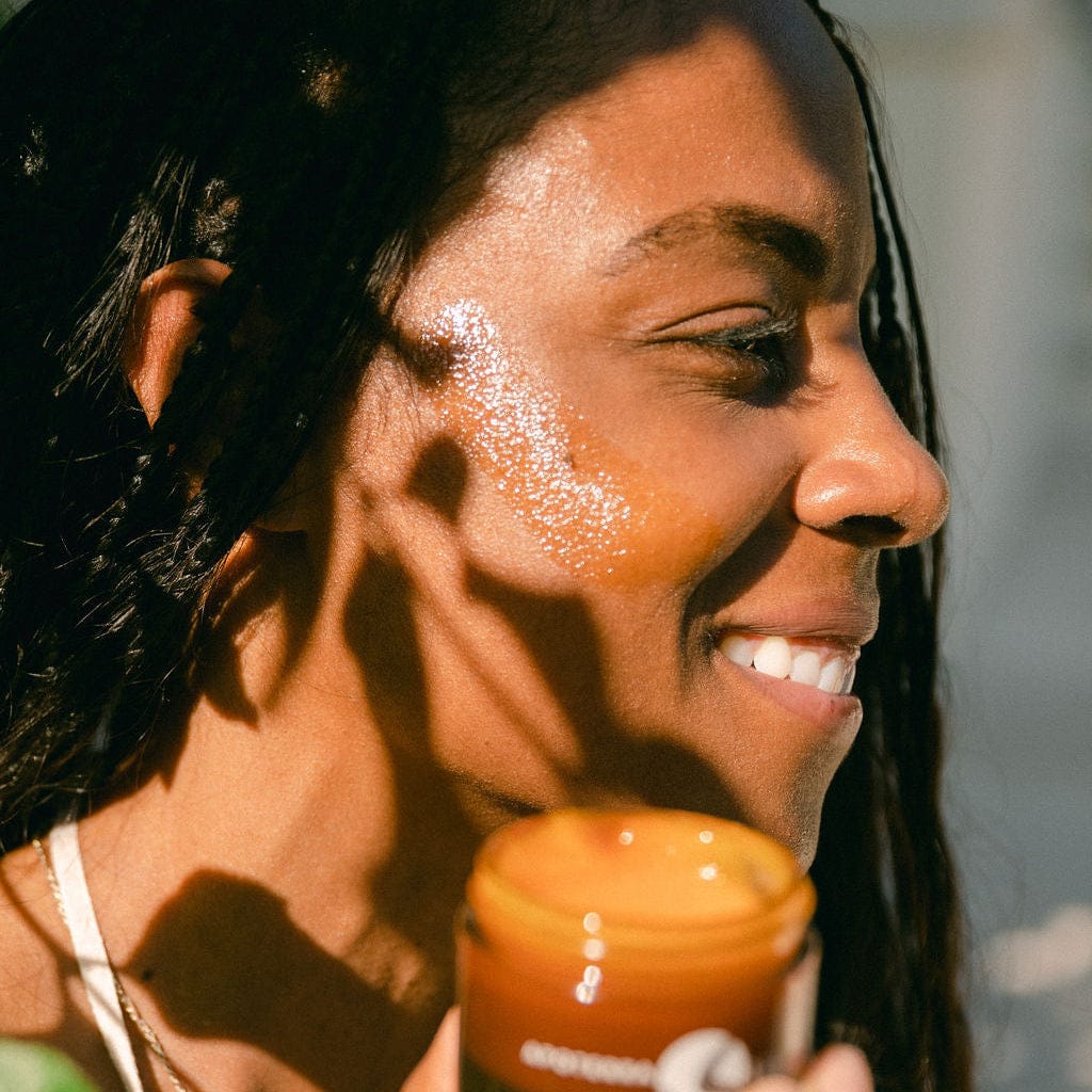 Application of Apoterra Vitamin C Regenerative Balm facial oil on skin, showcasing its smooth texture and brightening properties.
