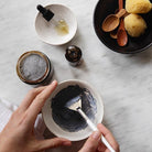 Apoterra Mineral Purifying Mask treatment being mixed in a bowl with charcoal and clay for deep cleansing skincare.