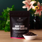 Razzmatazz Raspberry Burnt Sugar Black Tea by August Uncommon Tea in a 15-cup bag, showcasing the tea packaging with branding and product details.