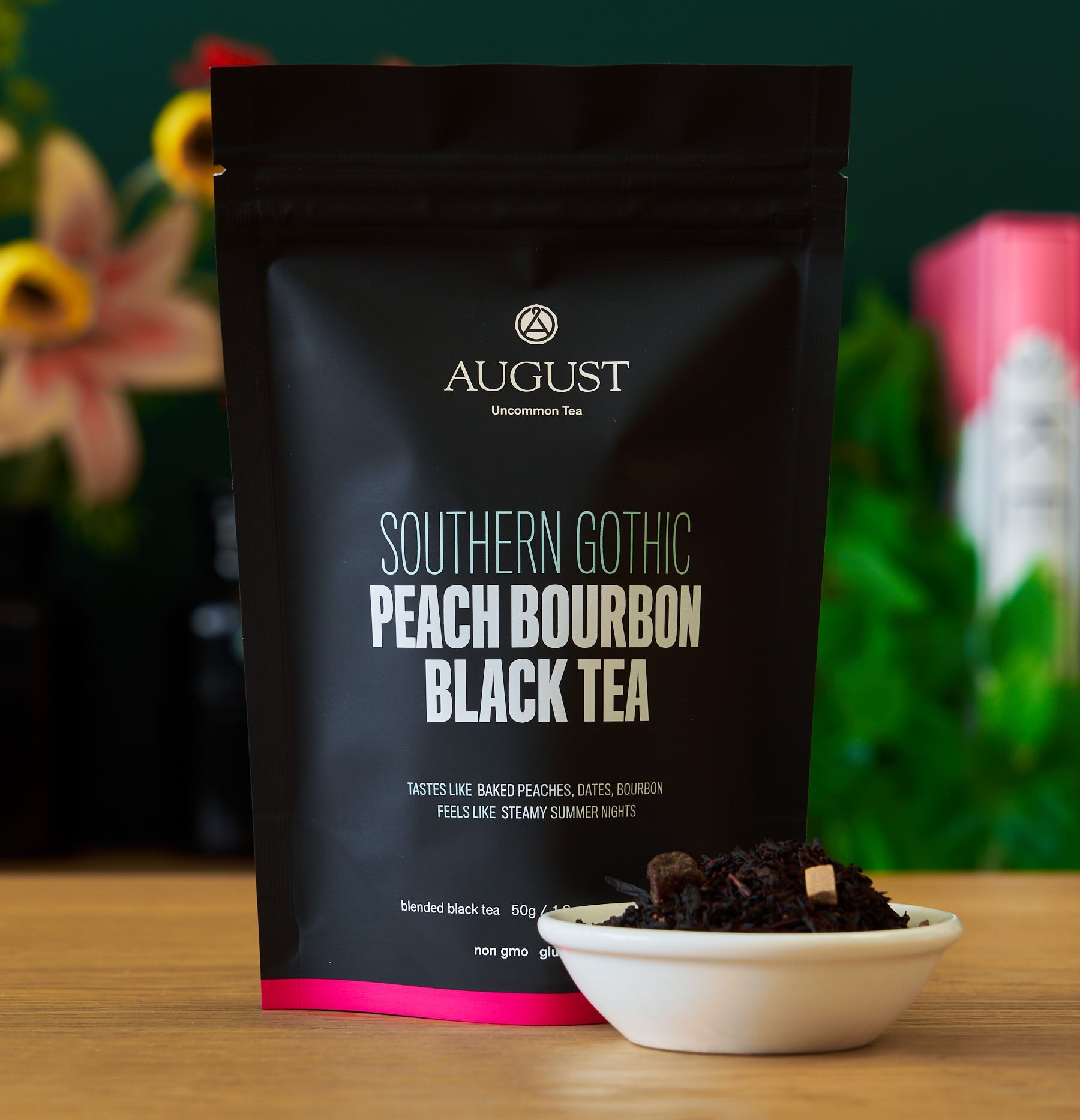 Black tea bag labeled Southern Gothic Peach Bourbon Black Tea from August Uncommon Tea, with a dark tea leaves and peach flavor hints.
