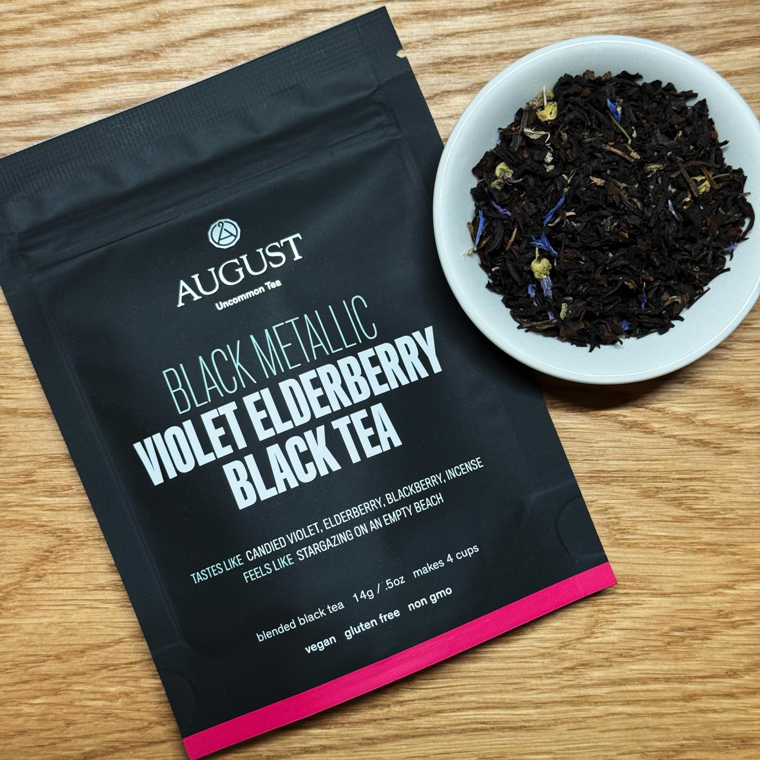Black metallic tin of August Uncommon Tea Violet Elderberry Black Tea, a black tea beverage in a decorative metal container.