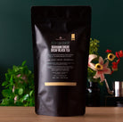 Decaf Low Country Bourbon Sugar Black Tea by August Uncommon Tea in a 15-cup bag, showcasing dark brewed tea with a rich aroma.