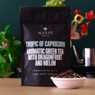 August Uncommon Tea Tropic of Capricorn Dragonfruit Melon Green Tea in a 15-cup bag, vibrant green tea leaves with fruit-infused flavor
