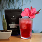Mojave Smoky Hibiscus Cherry Tea bag by August Uncommon Tea, herbal tea with low caffeine and vibrant tea leaves.