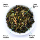Bag of August Uncommon Tea Superbloom Sweet Lemon Oolong Green Tea in a 15-cup brewing bag, with fresh lemon and green tea leaves visible.