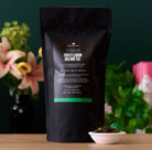 August Uncommon Tea Superbloom Sweet Lemon Oolong Green Tea in a 15-cup bag, showcasing fresh lemon and green oolong tea leaves.