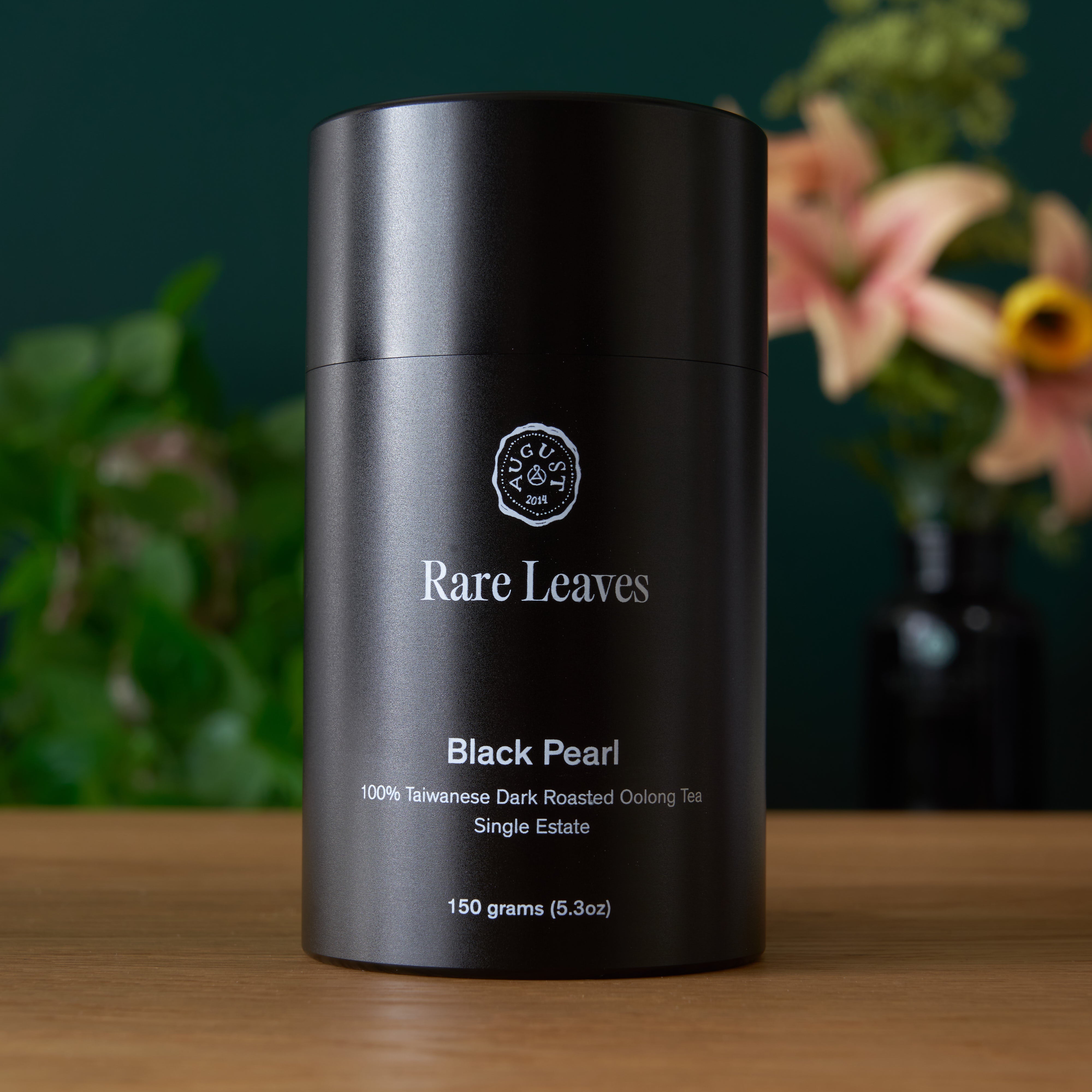 Black Pearl Taiwanese dark roasted oolong tea by August Uncommon Tea in a 150g tin, showcasing the rich, dark roasted leaves.