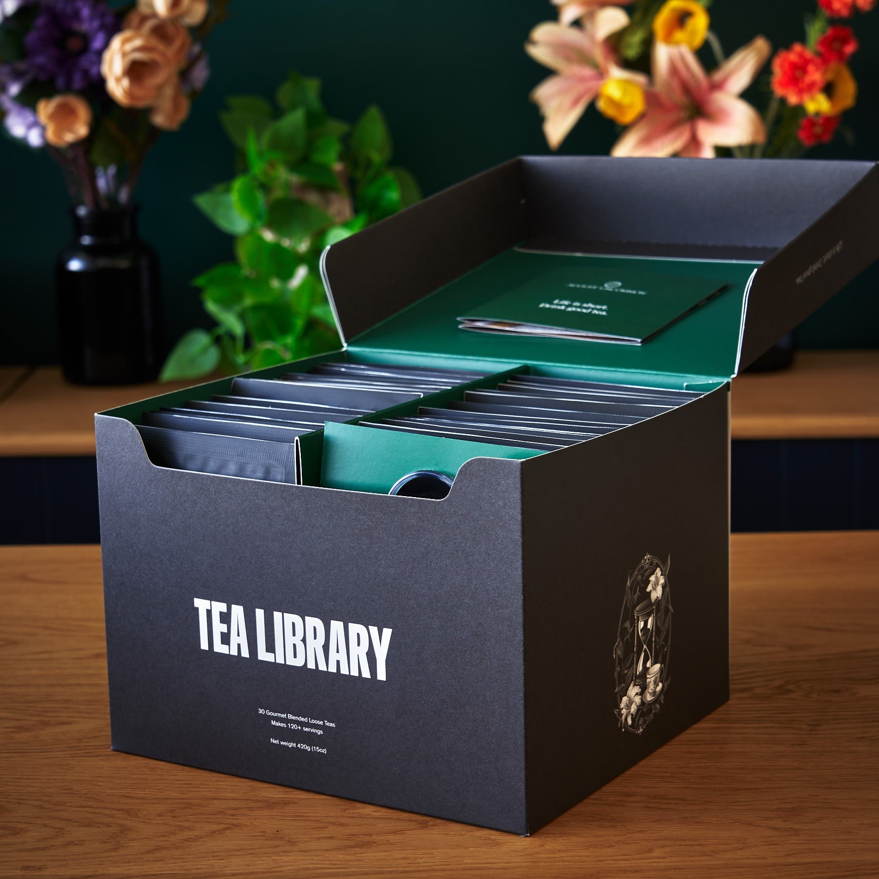 August Uncommon Tea Deluxe 30 Tea Sampler box with assorted tea tins and packaging, showcasing a variety of tea flavors.