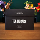 August Uncommon Tea Deluxe 30 Tea Sampler box with assorted tea tins, showcasing a variety of tea flavors in an elegant collection.