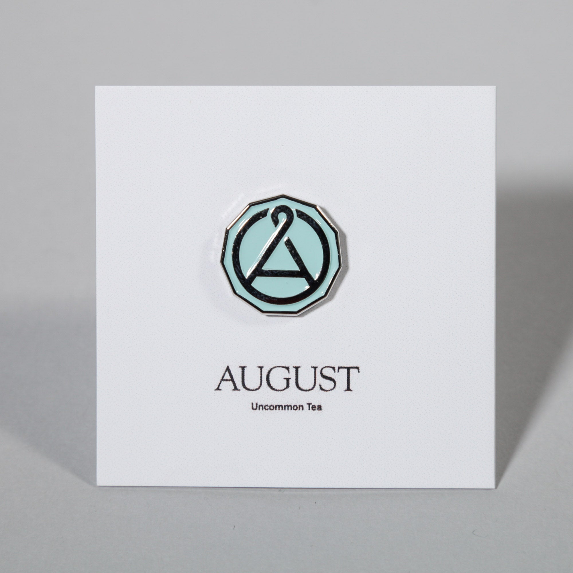 August Seal enamel pin from August Uncommon Tea swag collection, featuring a detailed seal design on a metal pin.