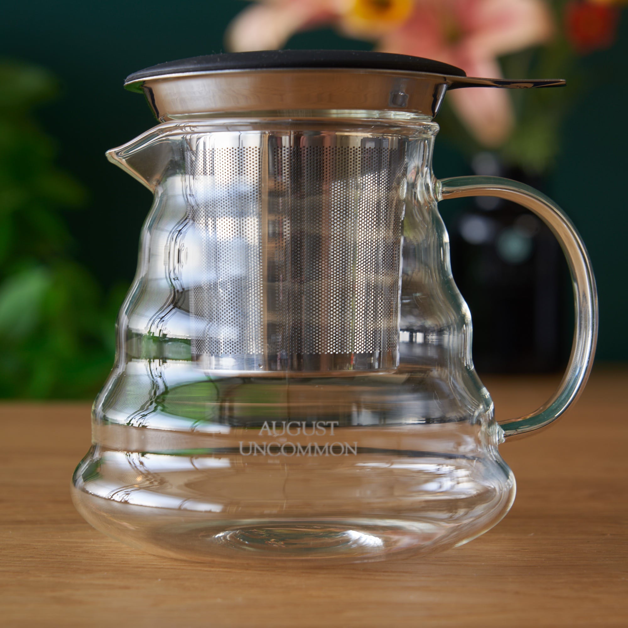 Two-cup glass teapot from August Uncommon Tea, showcasing clear glass body, lid, and spout, ideal for brewing and serving tea.