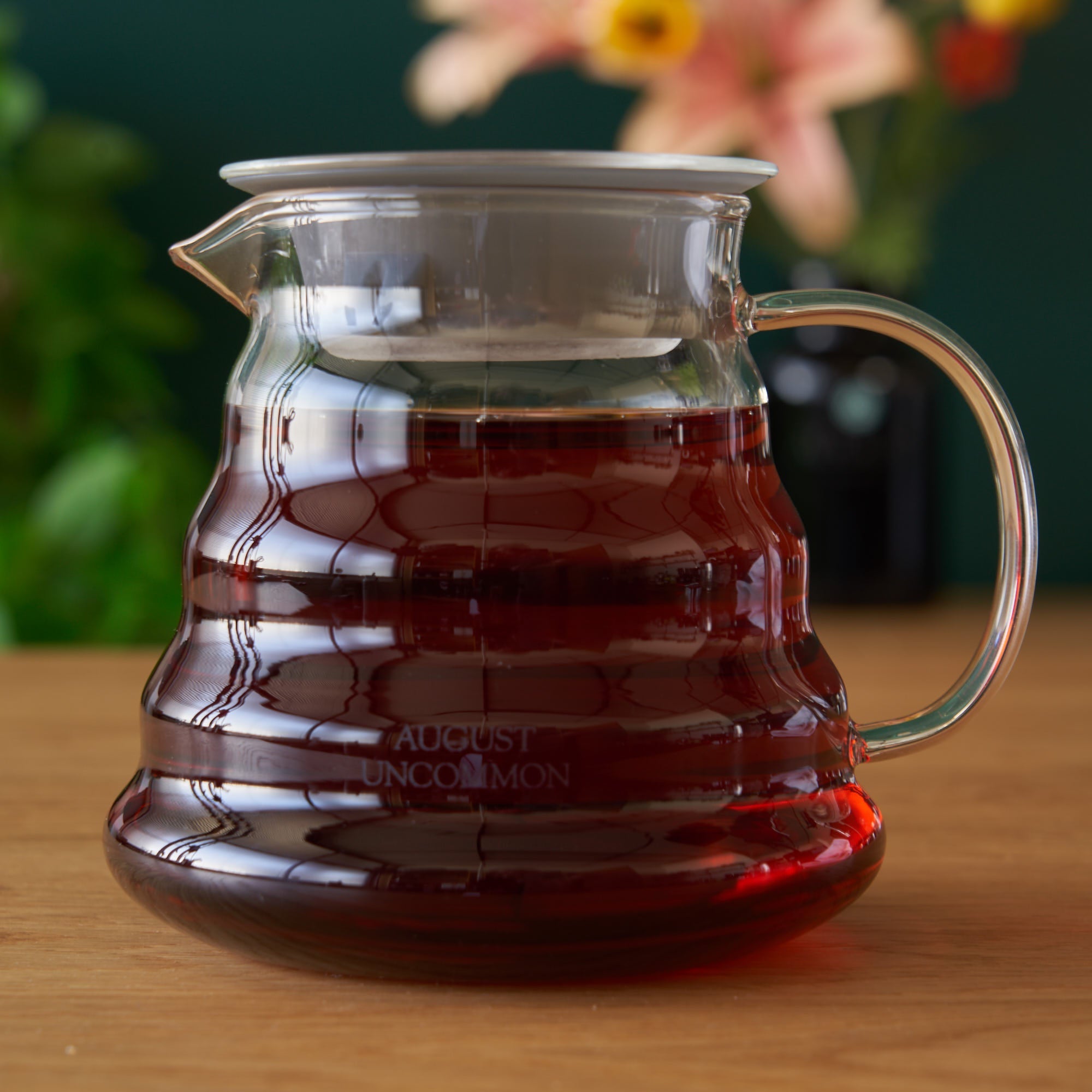 Two cup glass teapot by August Uncommon Tea, showcasing clear glass body, lid, and handle, ideal for brewing and serving tea.