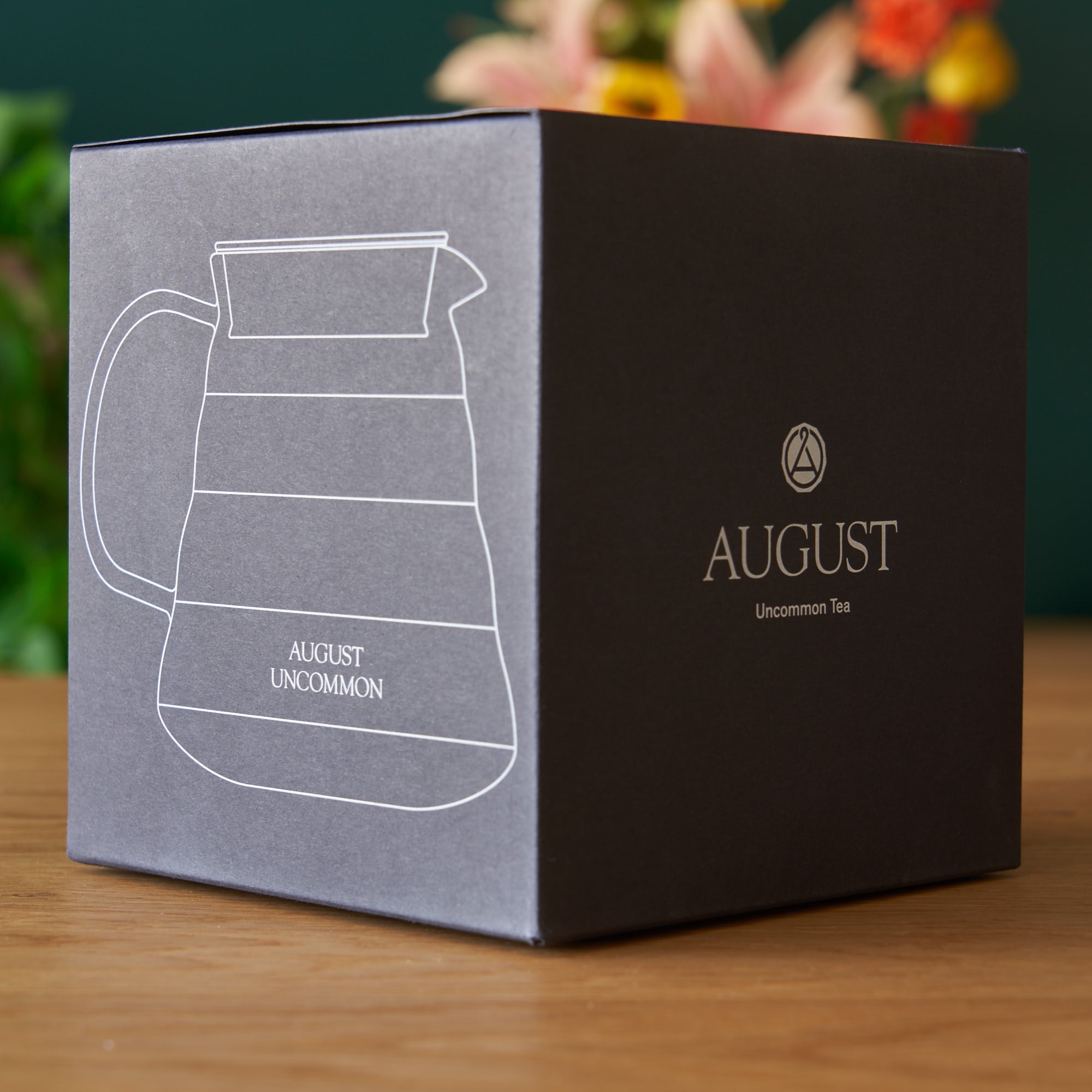 Clear glass two-cup teapot from August Uncommon Tea, showcasing a simple, elegant design for brewing tea.