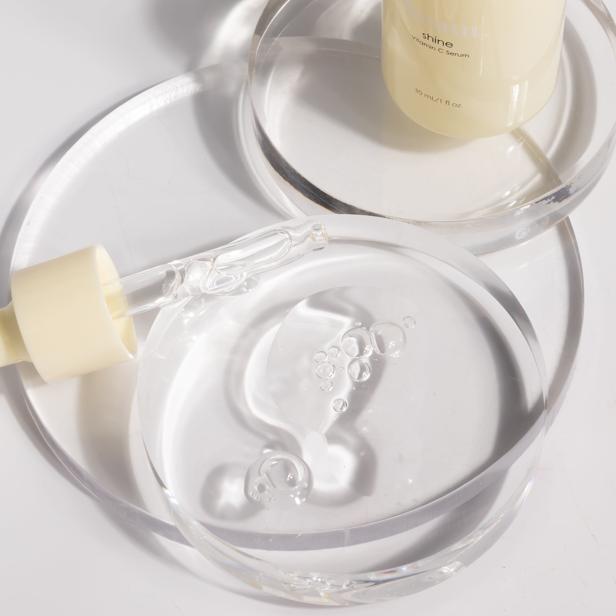Two bottles of Beaut.BeautyCo. Shine Vitamin C Serum with clear glass containers and dropper applicators.