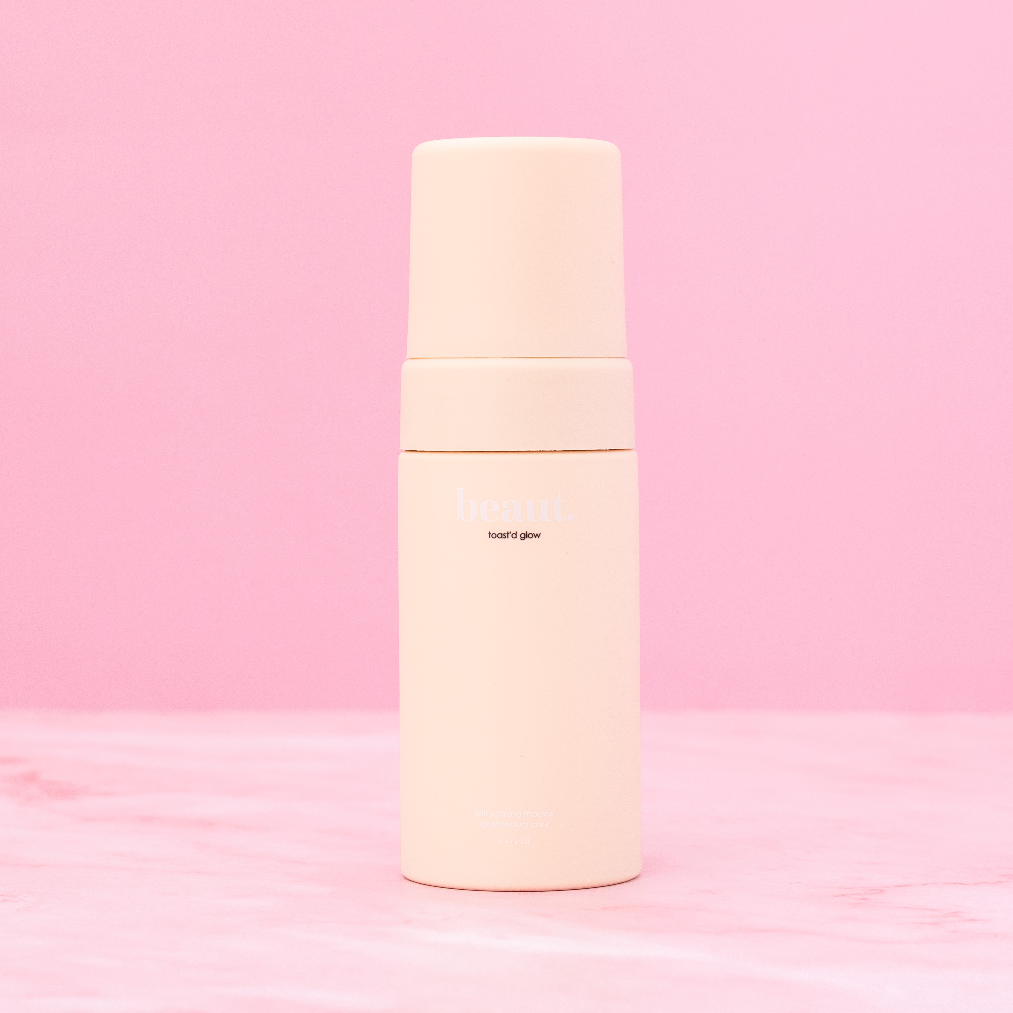Beaut.beautyco. Toast'd Glow skincare product with glowing formula in a sleek jar, featuring a light-colored, luminous finish.