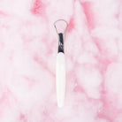Pink tongue scraper by beaut.beautyco with a smooth handle and textured scraping surface for oral hygiene.