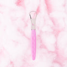 Pink tongue scraper by beaut.beautyco. with a curved design for effective oral hygiene and freshening breath.