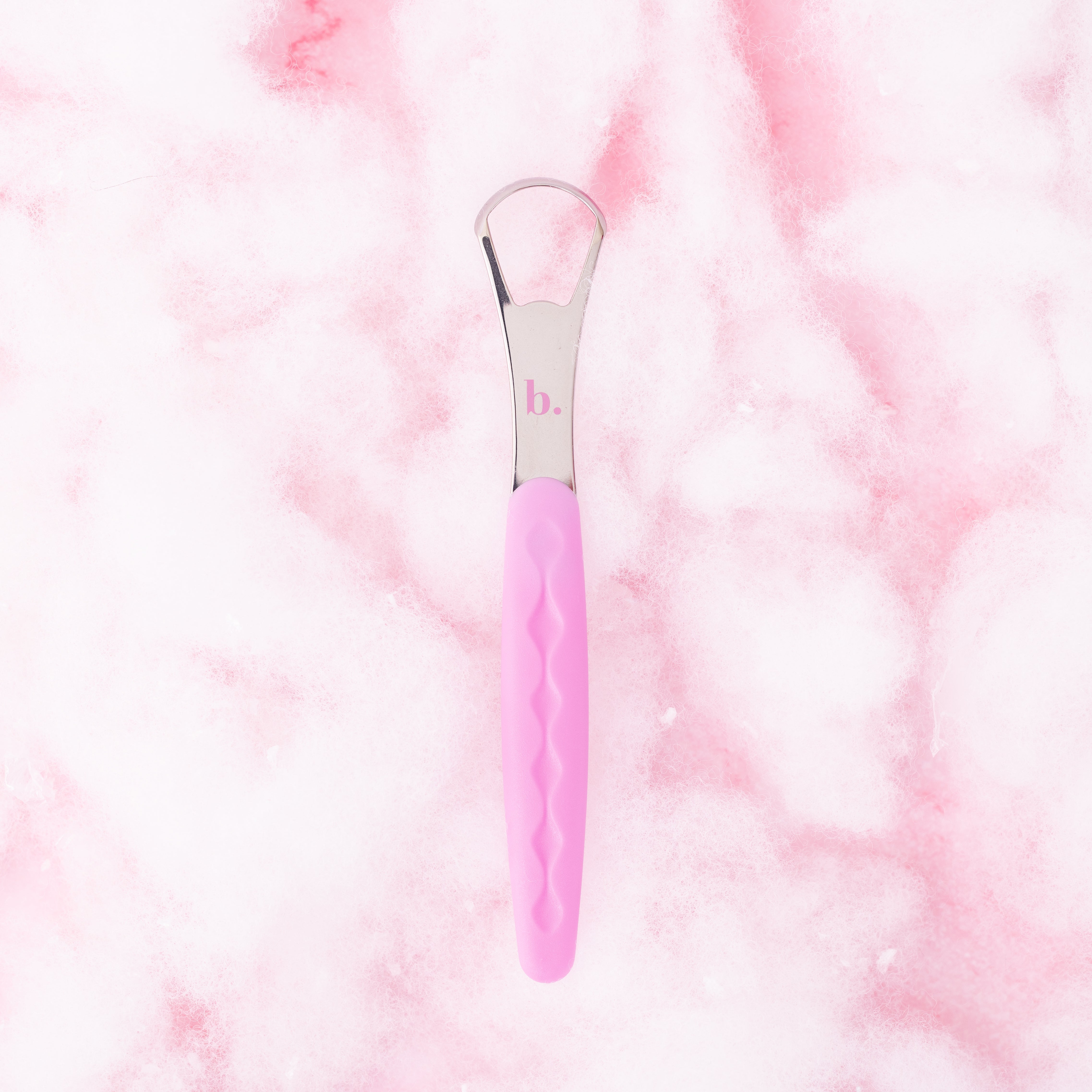Pink tongue scraper by beaut.beautyco. with a curved design for effective oral hygiene and freshening breath.