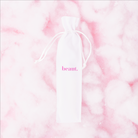 Pink tongue scraper from beaut.beautyco., with a smooth handle and curved scraping surface for oral hygiene.