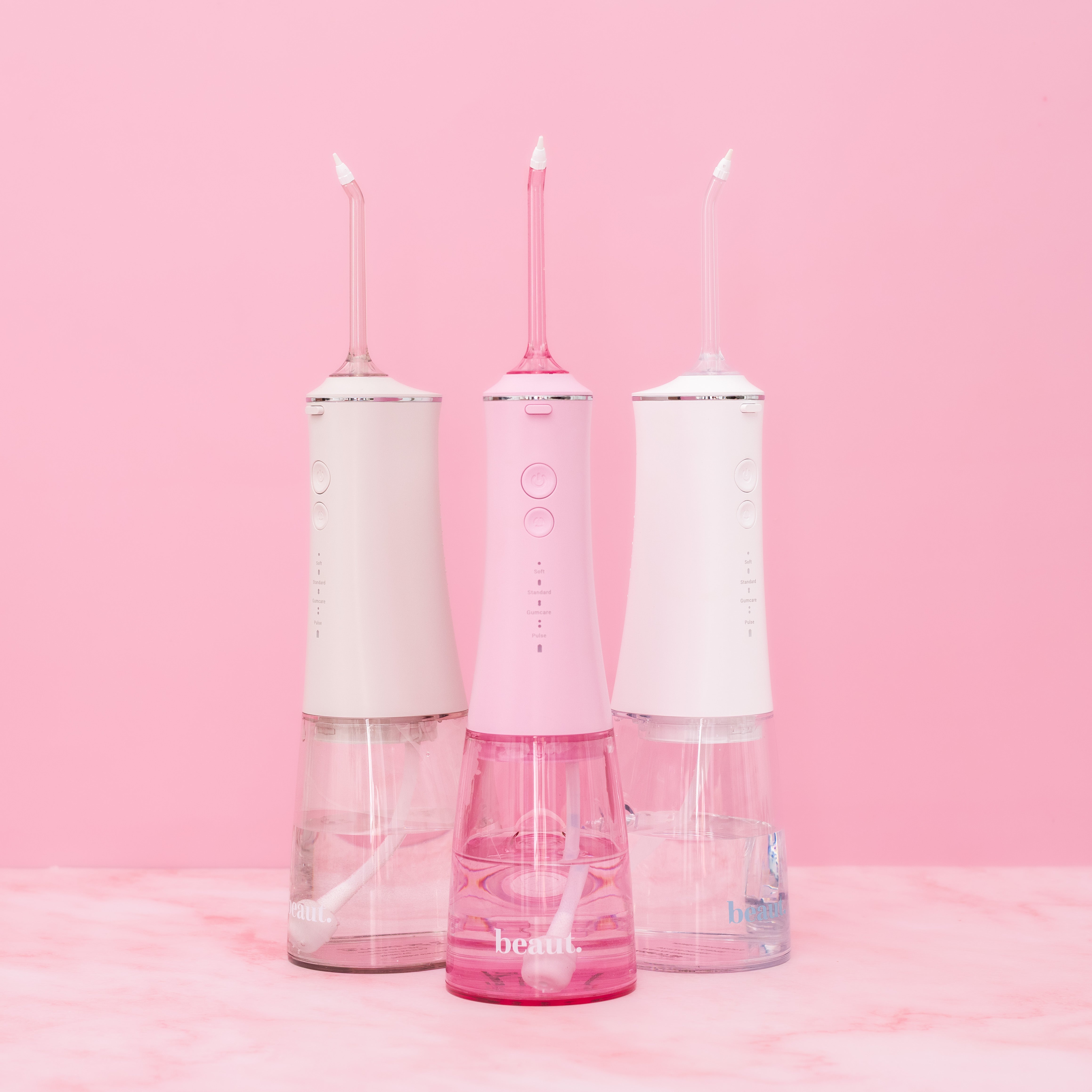 White H2O Hydroflossé water flosser by beaut.beautyco. with sleek design and multiple tips for effective oral hygiene.