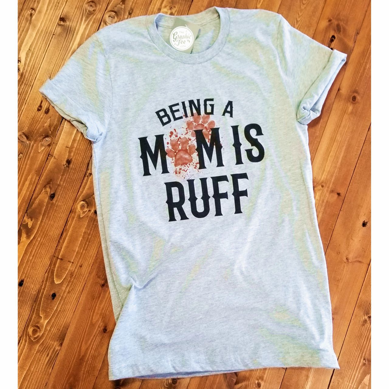 Being a Mom is Ruff athletic heather graphic T-shirt by The Graphic Tee, featuring a casual short-sleeve design with printed text.