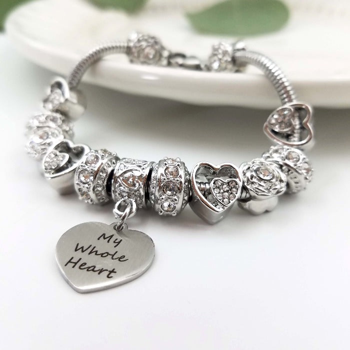 Silver birthstone bracelet from Bella's Yard featuring a heart-shaped charm and colorful gemstone accents.
