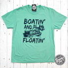 Blue pigment-dyed Boatin' and Floatin' graphic tee by The Graphic Tee, showcasing boat and float images on a casual short-sleeve shirt.