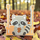 Swinging raccoon freshie air freshener from Bug & Bean Freshies hanging with a playful raccoon design.