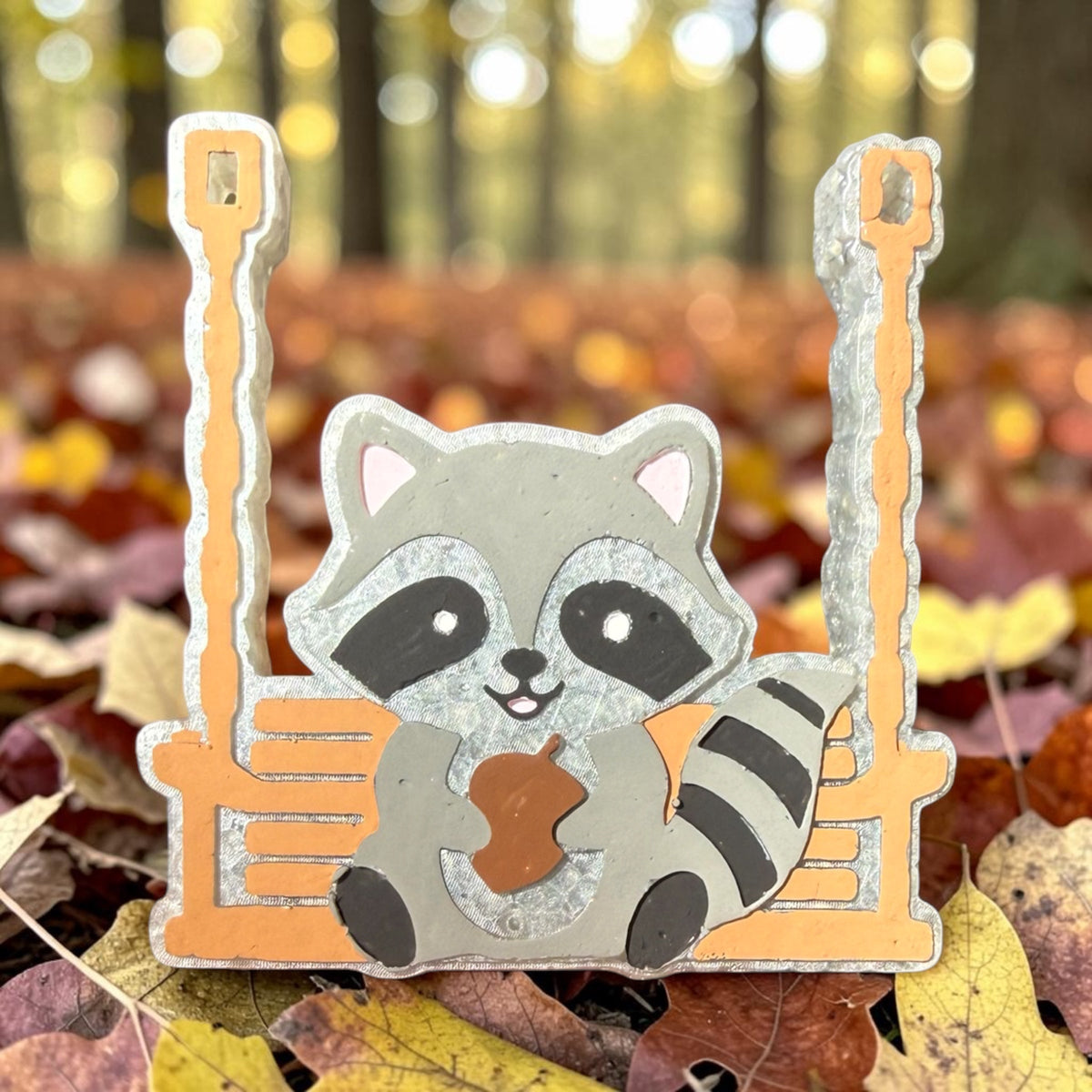 Swinging raccoon freshie air freshener from Bug & Bean Freshies hanging with a playful raccoon design.
