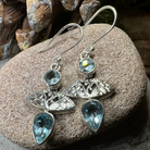 Celtic Morning Blue Topaz Dangle Earrings by Celtic Crystal Design Jewelry featuring sparkling blue topaz stones and intricate Celtic detailing.