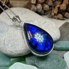 Large galaxy blue labradorite pendant necklace with Celtic crystal design jewelry, showcasing vibrant iridescent stone details.