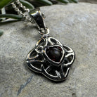 Amethyst Celtic Knot pendant necklace by Celtic Crystal Design Jewelry featuring intricate knot design and a purple gemstone.