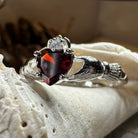 Celtic Crystal Design Jewelry garnet Claddagh ring with detailed Celtic knots and a central red garnet gemstone.
