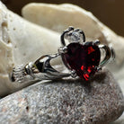 Garnet Claddagh ring by Celtic Crystal Design Jewelry featuring a detailed gold-tone band and heart and hands design.