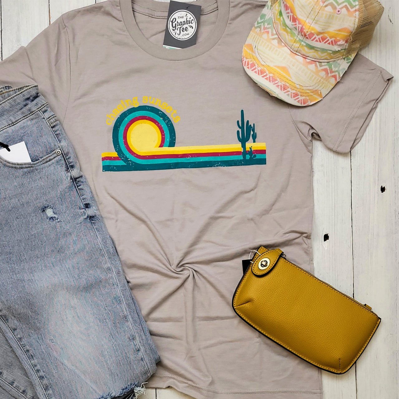 The Graphic Tee Chasing Sunsets Retro SS Graphic T-shirt with vibrant sunset and mountain design on soft fabric.