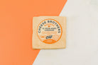 A block of 15-year-aged cheddar cheese from Cheese Brothers, Inc., showcasing its rich, firm texture and deep golden color.