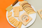 A block of 15-year-aged cheddar cheese from Cheese Brothers, Inc., showing a crumbly texture and rich orange color.