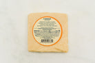 A wedge of 15-year-aged cheddar cheese from Cheese Brothers, Inc., showing its firm texture and rich, golden color.