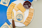 A wedge of 8-year-aged cheddar cheese from Cheese Brothers, Inc., showing its firm texture and rich orange color.